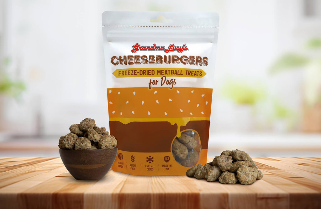 Grandma Lucy's Cheeseburger Meatball dog treat bag displayed on a kitchen counter alongside a bowl filled with meatballs.