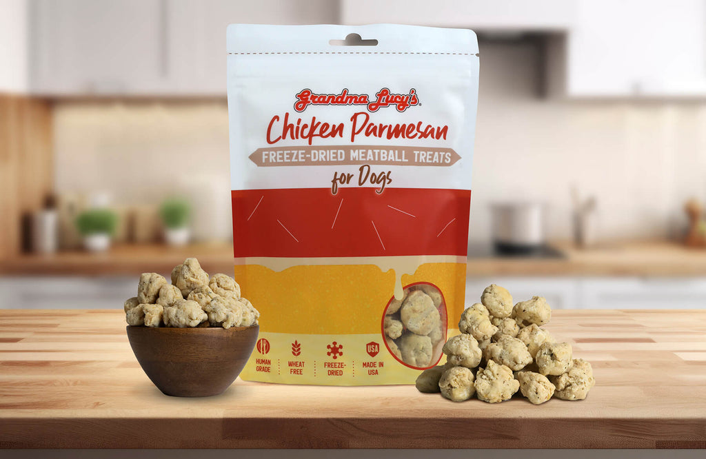 Grandma Lucy's Chicken Parmesan Meatball dog treat bag displayed on a kitchen counter alongside a bowl filled with meatballs.