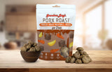 Grandma Lucy's Pork Roast Meatball dog treat bag displayed on a kitchen counter alongside a bowl filled with meatballs.