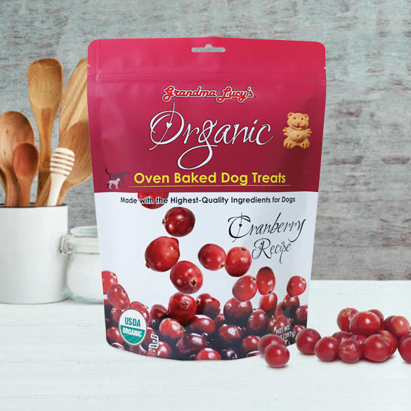 Organic oven-baked cranberry dog treats by Grandma Lucy's displayed on a kitchen counter, showcasing their all-natural ingredients.
