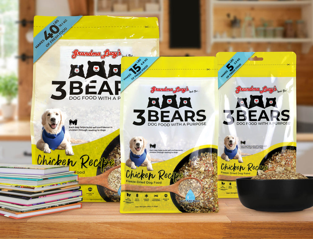 Three sizes of Grandma Lucy's freeze-dried 3 Bears chicken dog food bags displayed on a wooden kitchen countertop.