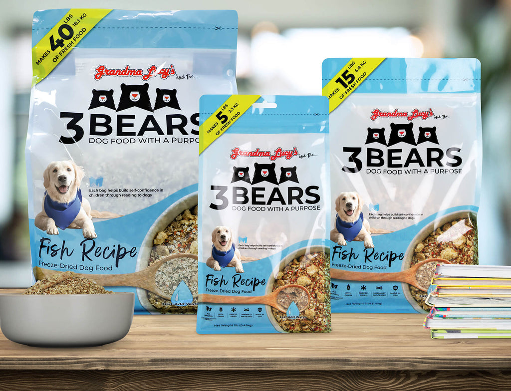 Three sizes of Grandma Lucy's freeze-dried 3 Bears fish dog food bags displayed on a wooden kitchen countertop.