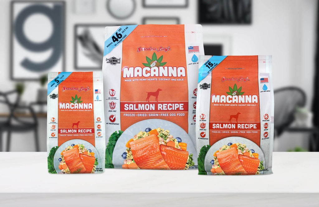 Three sizes of Grandma Lucy's freeze-dried Macanna salmon dog food bags displayed on a kitchen countertop.